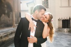 a man in a tuxedo hugging a woman