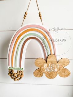 a wooden rainbow hanging on the wall with a sign that says baker & oak above it