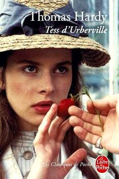 a woman wearing a straw hat holding a strawberry