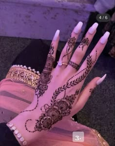 a woman's hand with henna tattoos on it