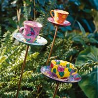 three teacups are sitting on small plates in the garden