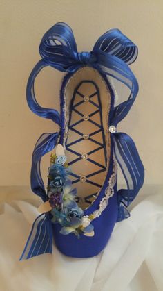 a close up of a shoe with flowers on the bottom and blue ribbon around it