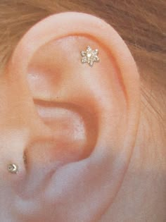 a woman's ear with two small flowers on it