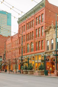 an empty city street lined with buildings and lights