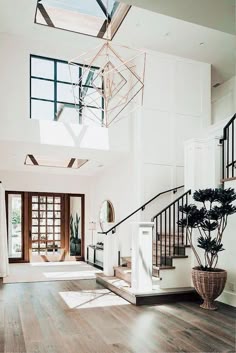 an open floor plan with wood floors and white walls, along with a staircase leading up to the second floor