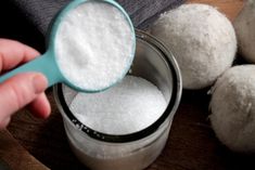 a person scooping sugar out of a jar