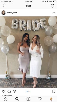 two women standing next to each other in front of balloons with the word bride on it