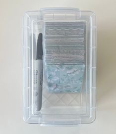 a plastic container filled with lots of papers and a pen in it's holder