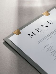 a close up of a menu on a table with gold trimmings and paper