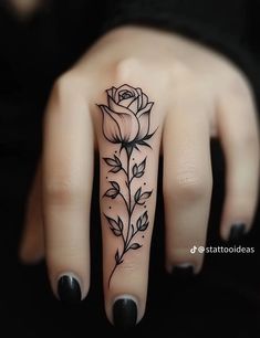 a woman's hand with a rose tattoo on it