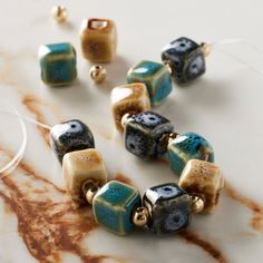 Find the Multicolor Reactive Glaze Ceramic Cube Beads, 10mm by Bead Landing™ at Michaels. These striking ceramic beads featuring a reactive glaze finish will add a playful touch to your accessory creations. On their own or mixed with complimentary stones and charms, these beads will make cute necklaces, bracelets and earrings and are also a wonderful accent for home décor projects and other crafts. These striking ceramic beads featuring a reactive glaze finish will add a playful touch to your ac Ceramic Beads Bracelet, Cute Necklaces, Bead Landing, Cube Beads, Glaze Ceramics, Reactive Glaze, Craft Corner, Cute Necklace, Ceramic Clay