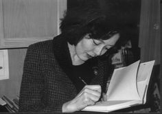 a black and white photo of a woman writing