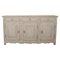 an old white painted sideboard with gold handles and knobs on the doors is isolated against a white background