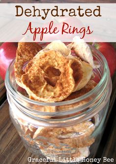 apple rings in a glass jar with apples and cinnamon on the side