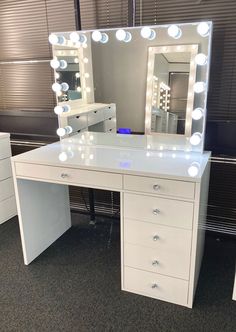 a white vanity with lighted mirror and drawers in a showroom or makeup parlor area