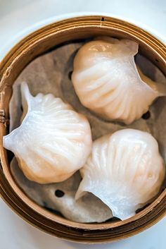 three dumplings in a wooden container on a table