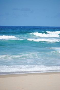 the ocean waves are rolling in to shore