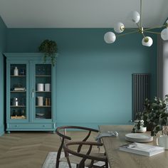 an empty dining room with blue walls and wooden table in front of bookshelves