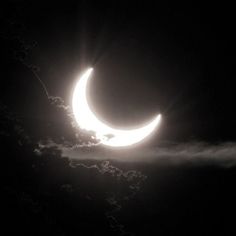 the moon is seen through the clouds in this black and white photo