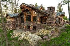 a stone and wood house in the woods