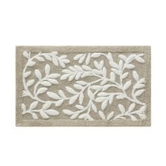 a white door mat with leaves on it