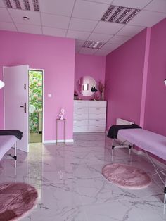 a pink and white room with two beds in the middle, one on the other side