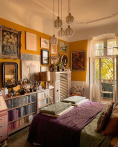 a bedroom with yellow walls and lots of pictures on the wall, including bookshelves