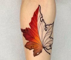 a woman's leg with an orange and red leaf tattoo on the left calf