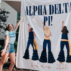 a woman standing in front of a sign that says, aloha delta pi