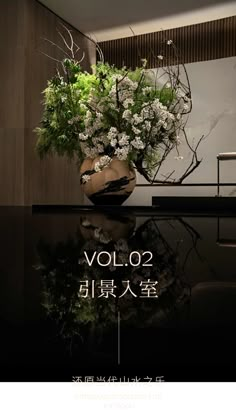 a vase filled with flowers sitting on top of a black table next to a wall