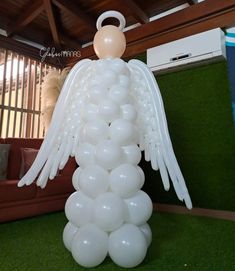 an angel balloon sculpture with white balloons on it