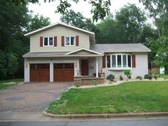 a two story house with red shutters on the front