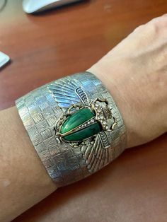 "Egyptian scarab green scarab cuff Wide cuff 2 inches, basket weave, thick silver antique plating over bronze vintage cuff. Open in back for ease of wearing. Winged layered scarab wings with large resin and crystal detailed dark emerald green scarab. Adjustable size 7,8,9 Rich vintage patina Lucky beetle. Speaks life. This is a show stopper. Gorgeous! Limited edition. \"Angelina Verbuni Designs\" Made in USA MyElegantThings" Art Deco Scarab Beetle, Bridal Hair Barrettes, Art Deco Inspired Jewelry, Scarab Beetle Earrings, Scarab Beetle Amethyst Jewelry, Scarab Bracelet Vintage, Scarab Bracelet, Bumble Bee Necklace, Silver Bridesmaid