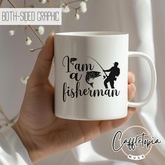 a person holding a white coffee mug with the words i am a fisherman on it