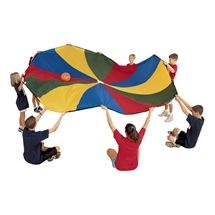 several children are playing with a large kite