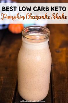 a glass jar filled with keto pumpkin cheesecake shake on top of a wooden table