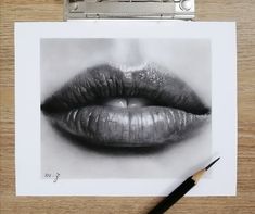 a pencil drawing of a woman's lips on top of a piece of paper