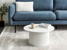 a living room with a blue couch and white coffee table in front of the couch