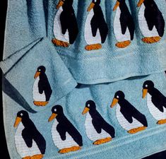 several towels with penguins on them sitting next to each other