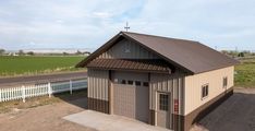 a small building with a metal roof and two garage doors on the side of it