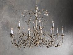 a chandelier hanging from the ceiling in a room with concrete walls and flooring