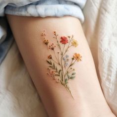 a woman's leg with flowers on it and the bottom part of her arm