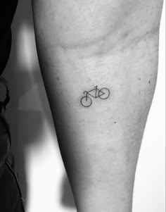 a black and white photo of a person's leg with a bike tattoo on it