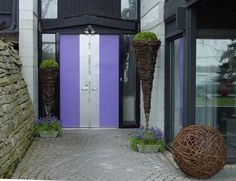 purple door and two tall planters in front of a house