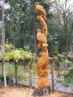 a carved wooden tree with two birds on it