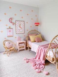 a pink and gold girls'bedroom with wicker bedspread, rattan chairs, and polka dot wallpaper