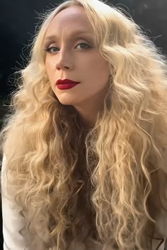 a woman with long blonde hair and red lipstick