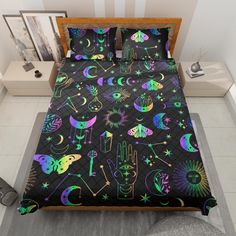 a bed covered in black and neon colored sheets with hand prints on the comforter