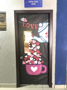 a door decorated with hearts and the words love is in front of a coffee shop