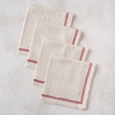 four red and white napkins sitting on top of a table